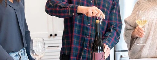 A man opening a wine bottle | Macy's Wine Shop